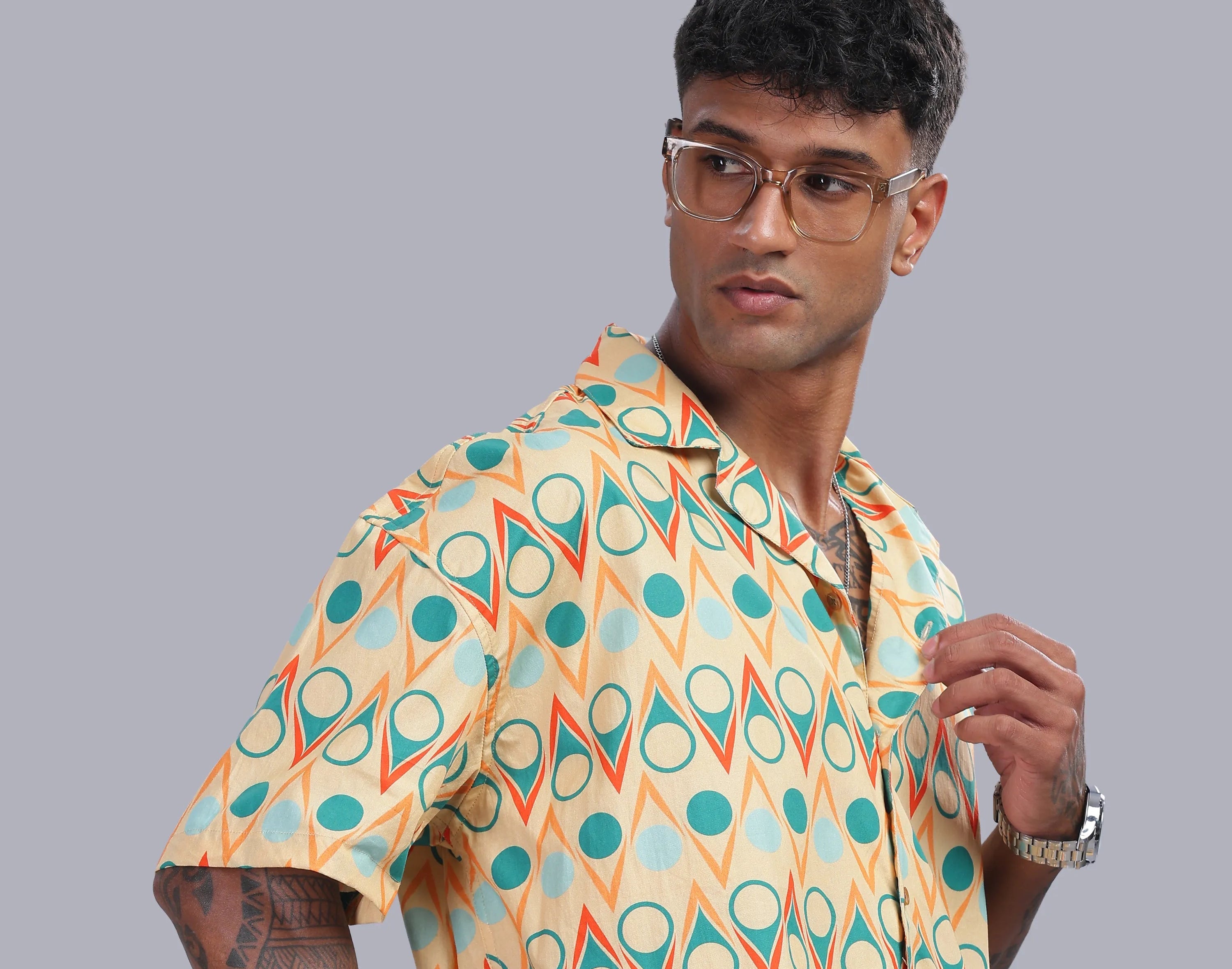 Man wearing a colorful patterned shirt against a gray background